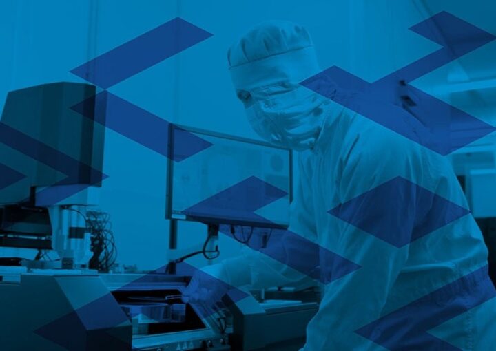 Ein*e Forscher*in im Reinraum bei der Arbeit mit hochpräzisen Geräten zur Mikro- oder Nanostrukturierung.