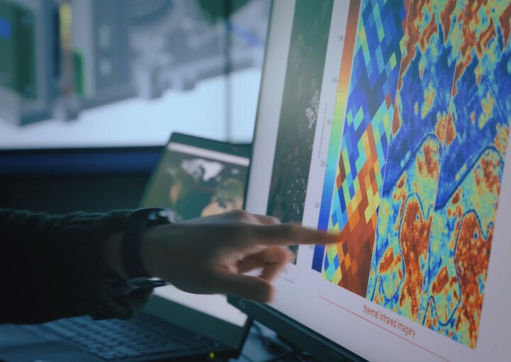 Finger zeigt auf thermografische Daten auf einem Monitor.