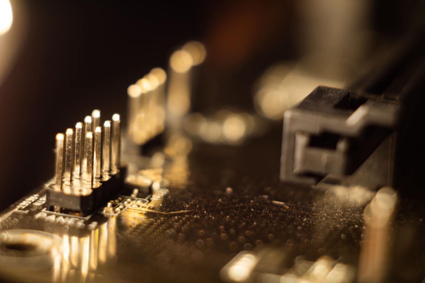 Makroaufnahme einer Leiterplatte mit Stiftleiste und Steckverbindung – typische Schnittstelle für elektronische Signalverbindungen. Macro shot of a circuit board with a pin header and connector - typical interface for electronic signal connections.
