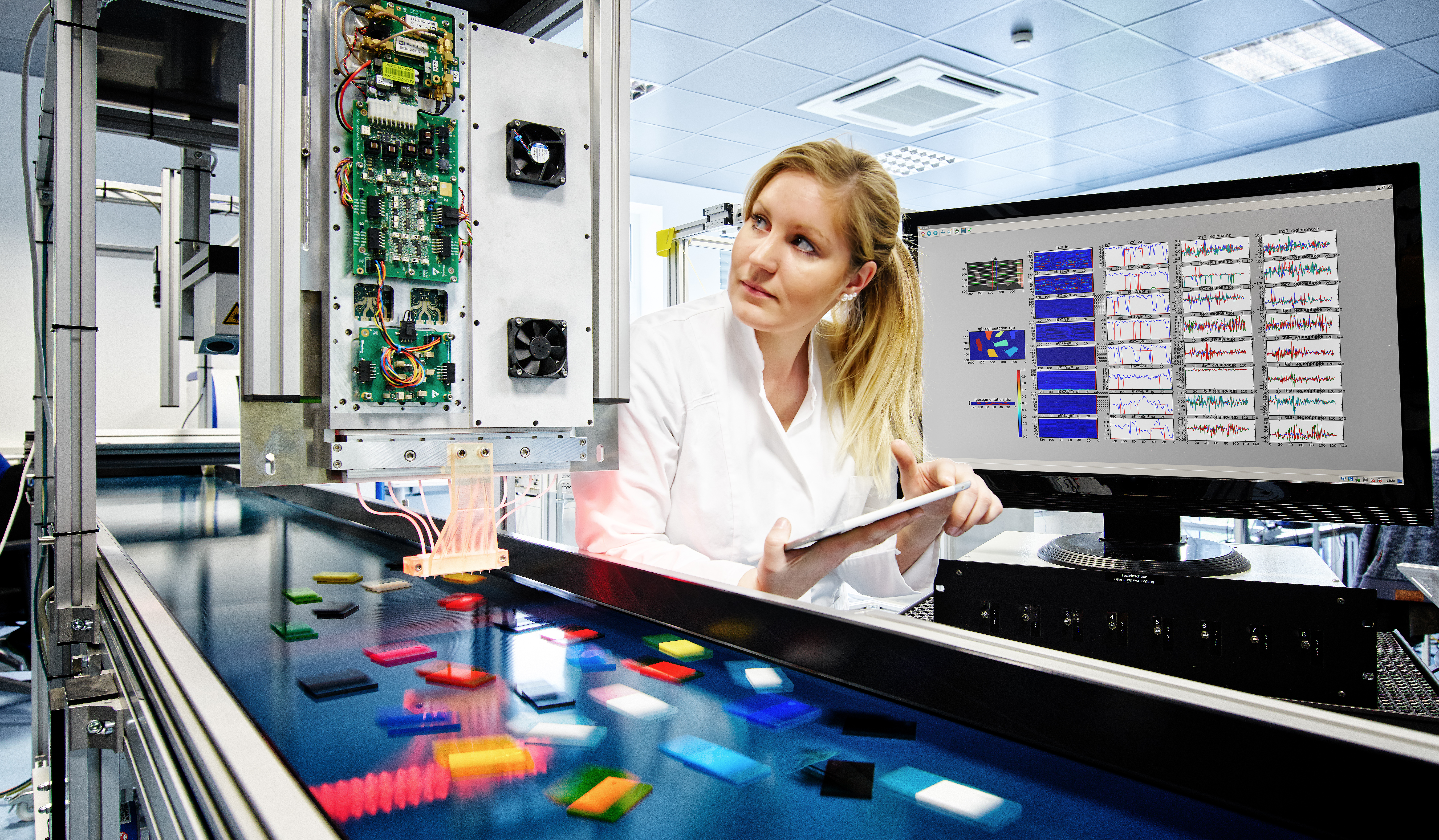 Terahertzsensorik: Verschiedene Kunsstoffe laufen auf einem Fließband unter Höchstfrequenz-Radarsensoren hindurch, ums sie zu vermessen und zu bestimmen. Terahertz sensing: Various plastics pass on a conveyor belt under high-frequency radar sensors for measurement and identification.