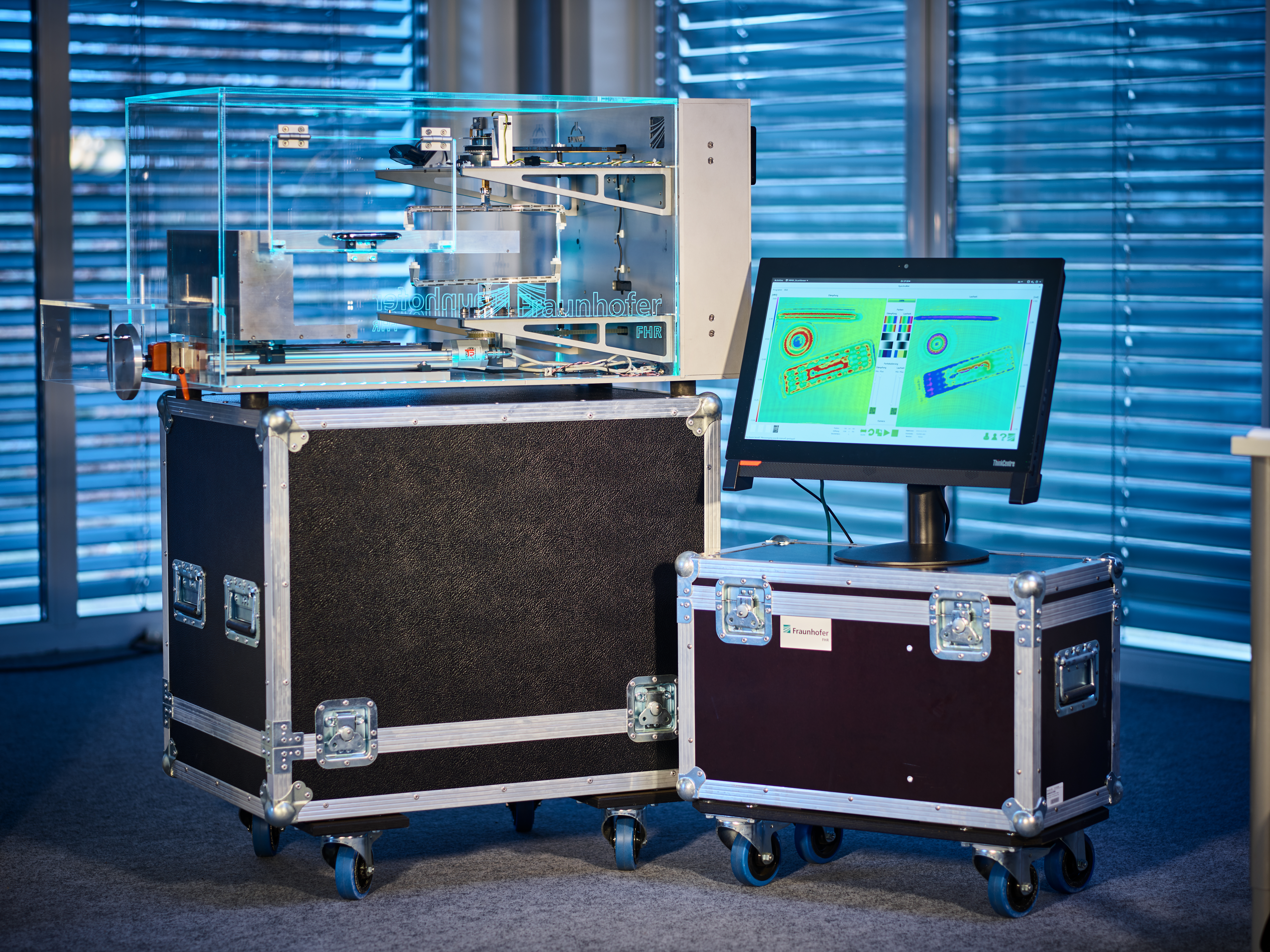 Terahertzsensorik: Ein Millimeterwellenscanner zur zerstörungsfreien Prüfung in einem transparenten Schaukasten macht das innere mehrerer Gegenstände auf einem Bildschirm sichtbar. Terahertz sensing: A millimeter-wave scanner for non-destructive testing inside a transparent display case makes the interior of several objects visible on a screen.