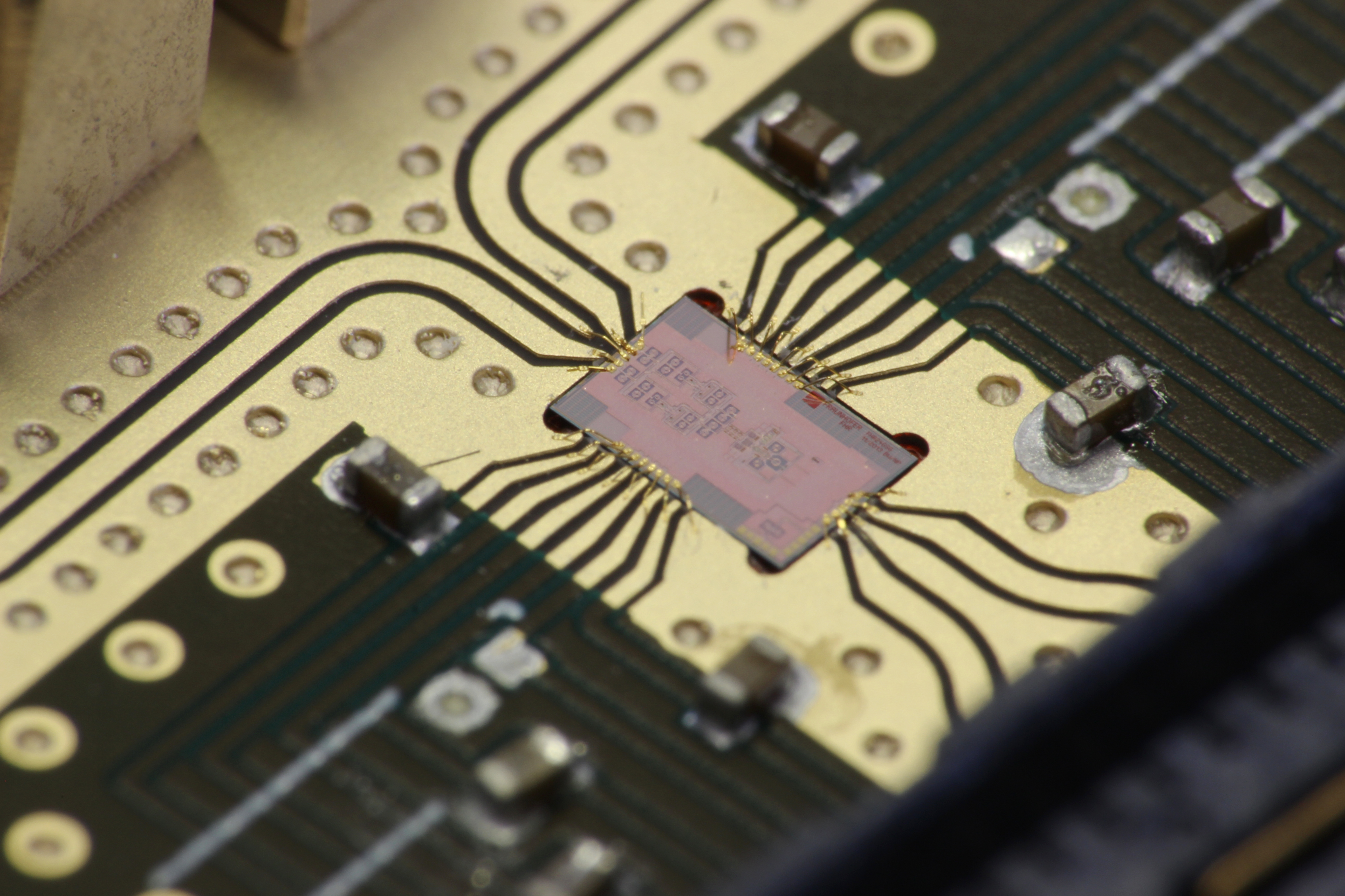 Fraunhofer FHR SiGe Chip für Terhaertzsensorik in der Senke einer Platine mit Bonddrähten. Fraunhofer FHR SiGe chip for terahertz sensing mounted in a PCB socket with bond wires.